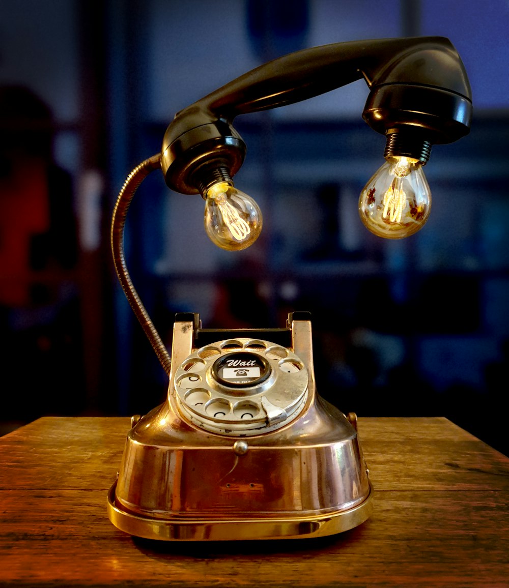 Telefono rotante dorato su tavolo di legno marrone