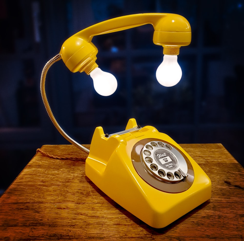 red and white rotary phone on brown wooden table