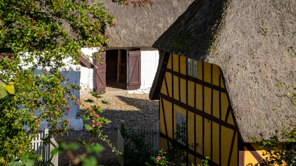 brown wooden house near green tree during daytime