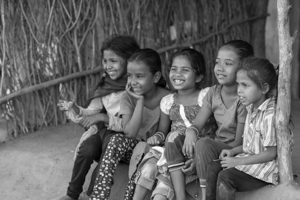 Foto en escala de grises de 3 niños sonriendo
