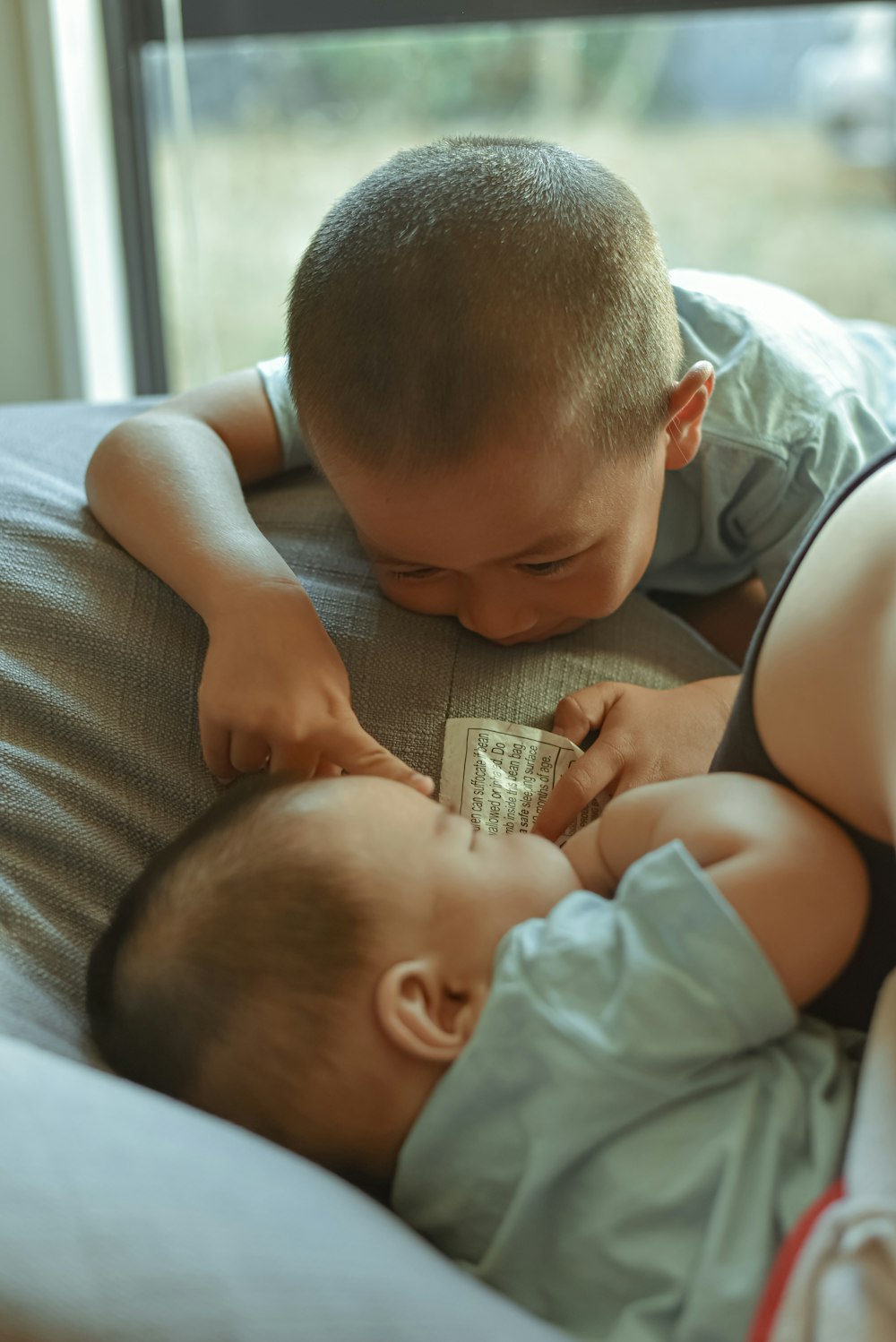 baby in blue shirt lying on bed