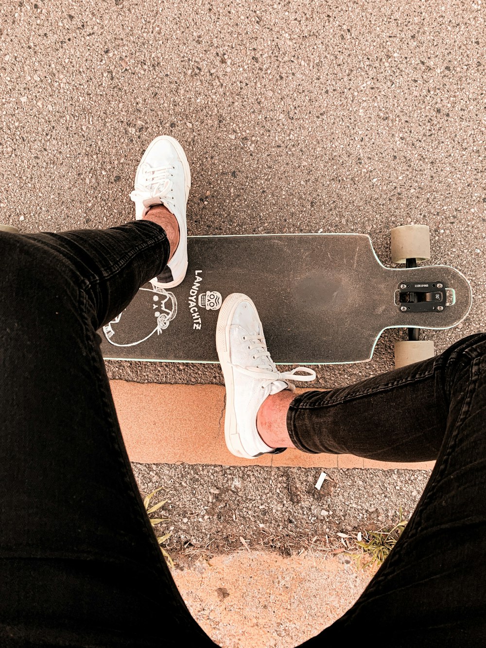 person in black pants and white sneakers