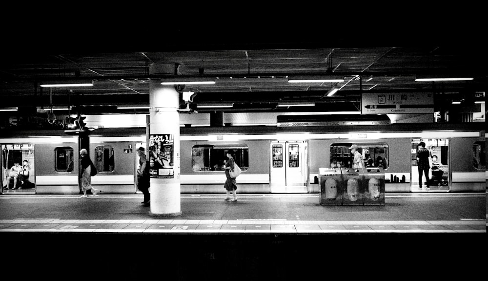 grayscale photo of people in train station