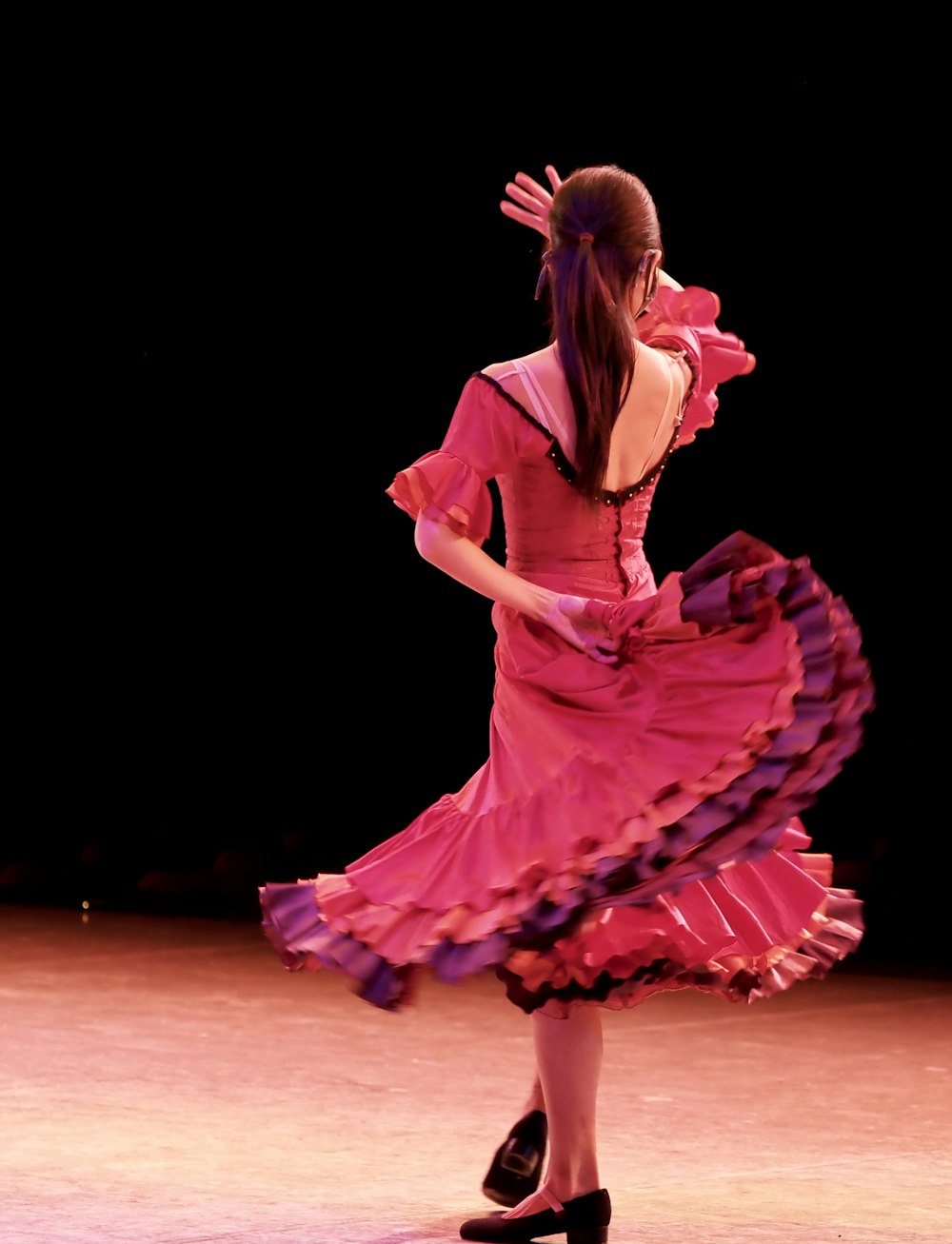 무대에 서 있는 분홍색 드레스를 입은 여자