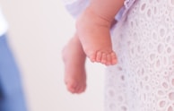 Side view of a baby's foot cast resting on a beige linen cloth, highlighting fine details.