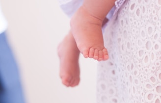 Side view of a baby's foot cast resting on a beige linen cloth, highlighting fine details.