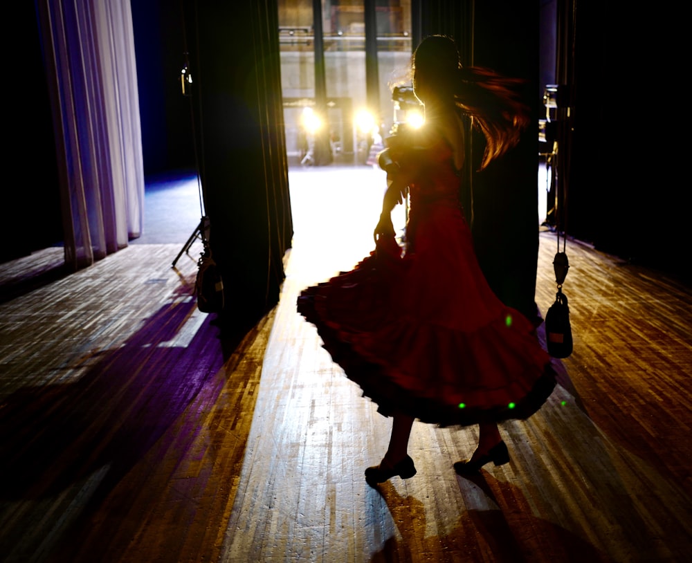 girl in white dress standing on brown wooden floor