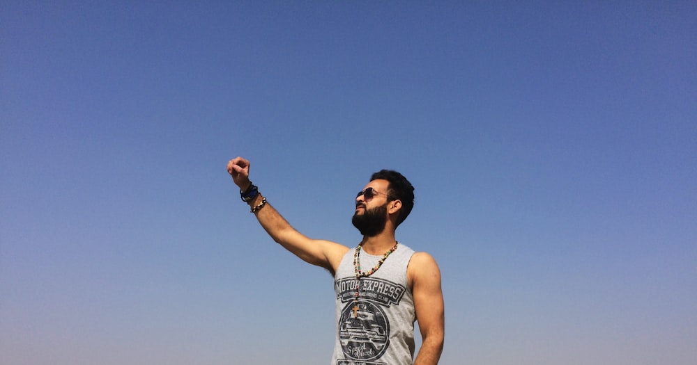 man in white tank top wearing black sunglasses