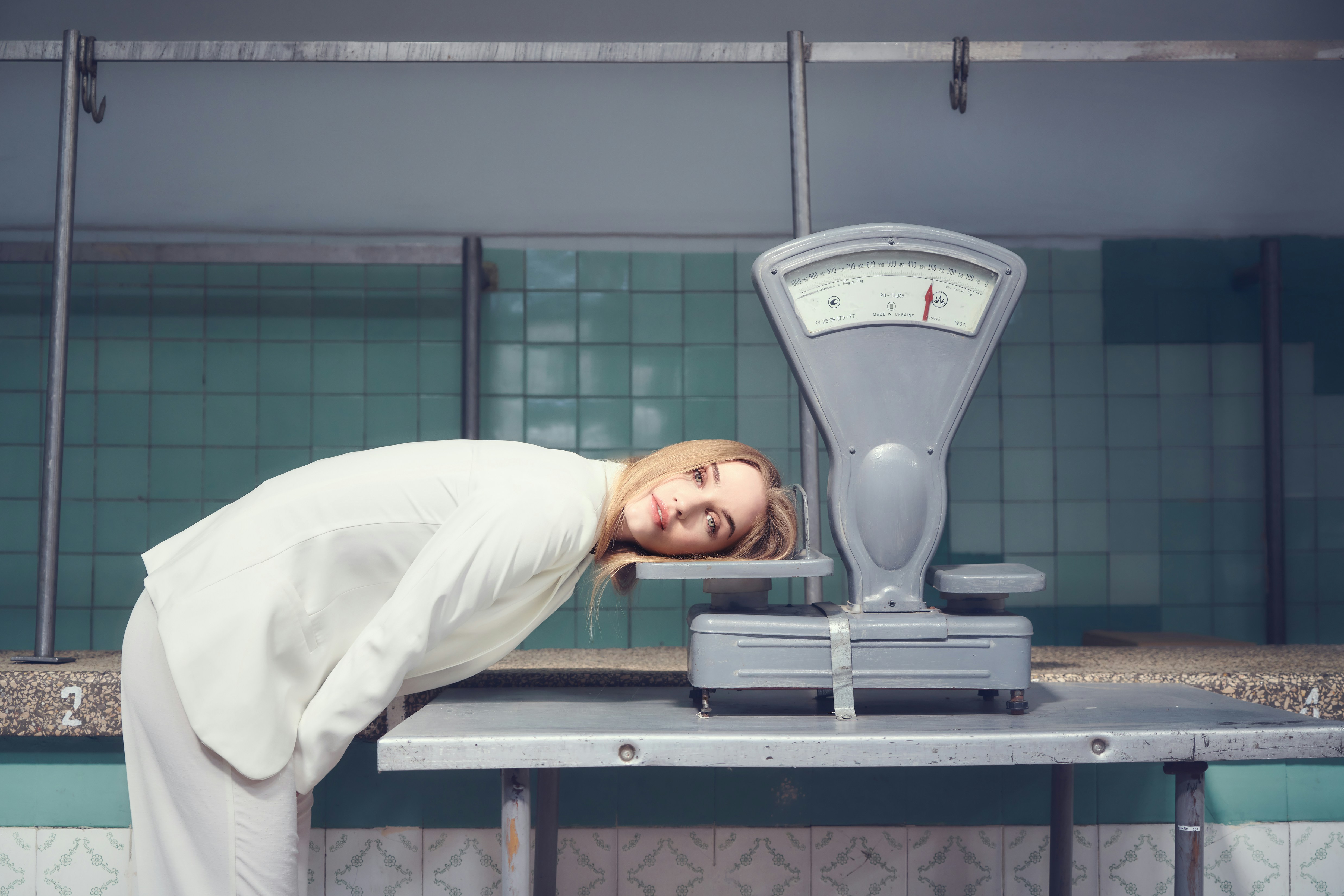 man-in-white-long-sleeve-shirt-standing-near-gray-weighing-scale