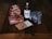 A collection of Swedish food items is arranged on a rustic wooden table. It includes a bag of gifflar pastries, a box of Annas Original Ginger Thins, a bottle of Skånska Spritfabriken cherry cordial, a box of Leksands Crispbread, and a small packet of snack mix.