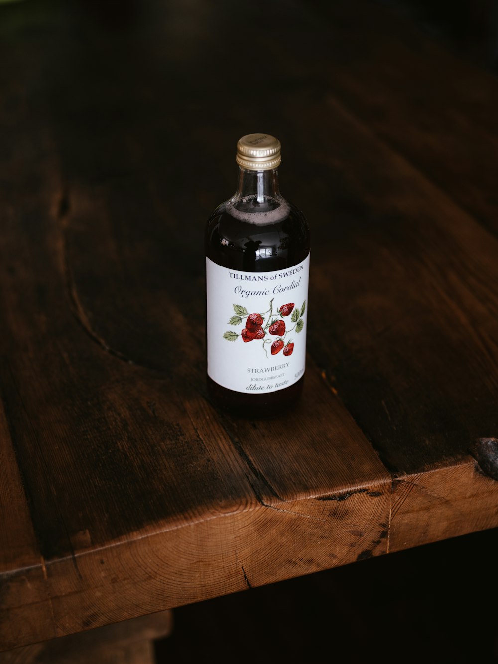 Botella de vidrio negro sobre mesa de madera marrón