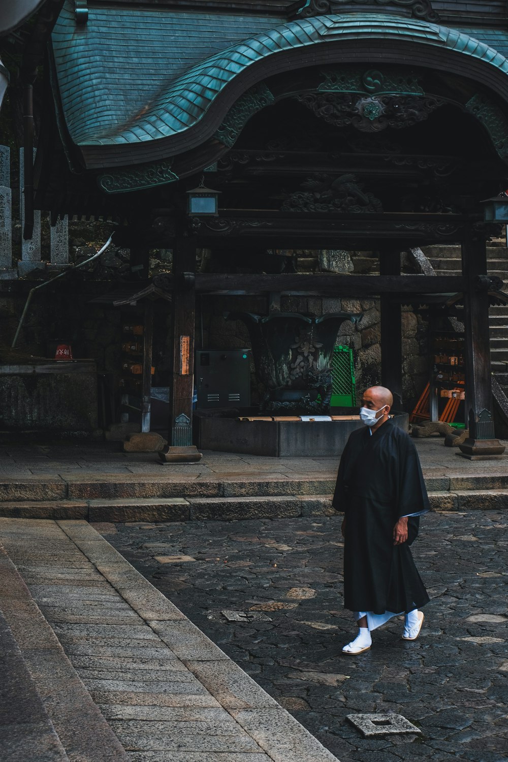 man in black thobe standing on sidewalk during daytime