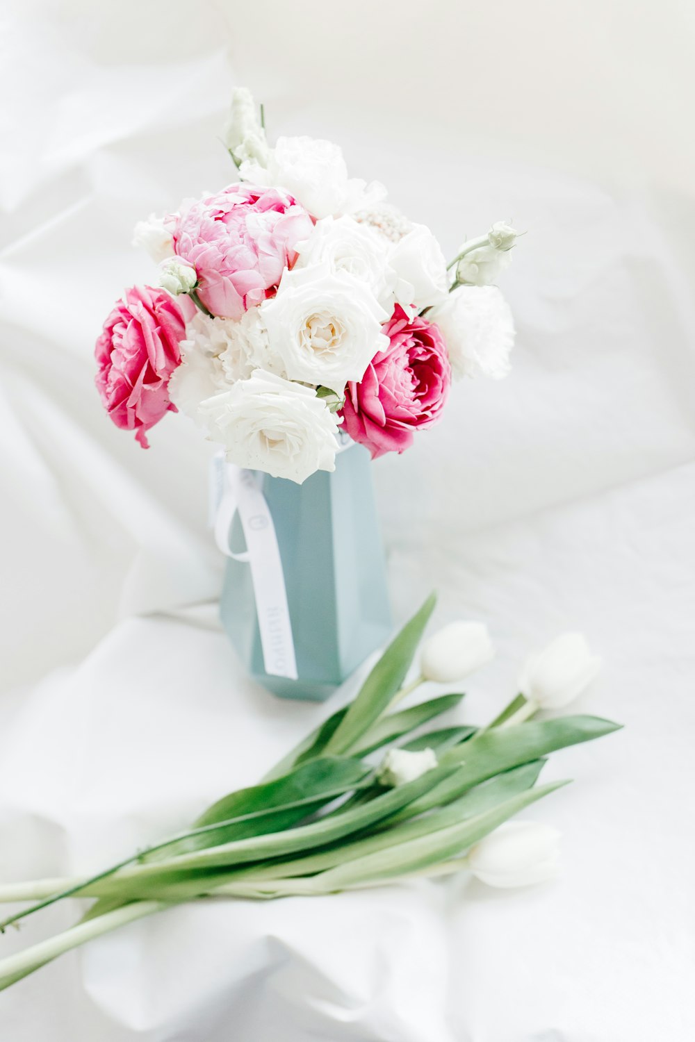 pink and white roses in white vase