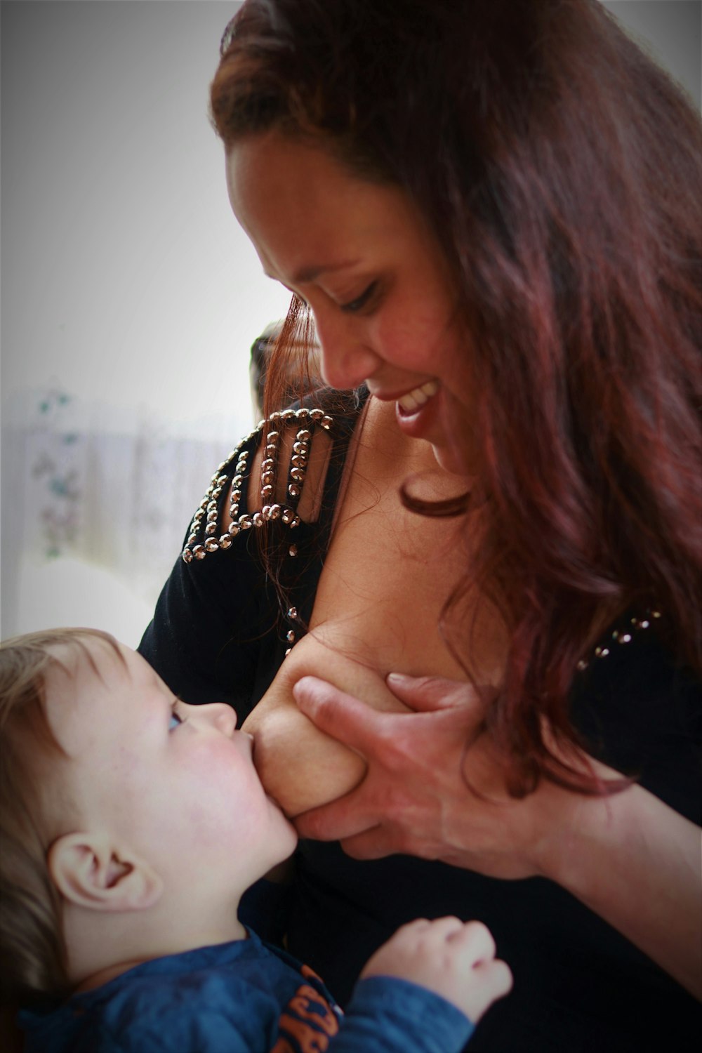 woman in black shirt carrying baby