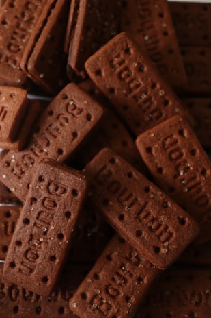 A collection of rectangular chocolate biscuits, each with the word 'Bourbon' embossed on top and small sugar granules sprinkled across the surface.