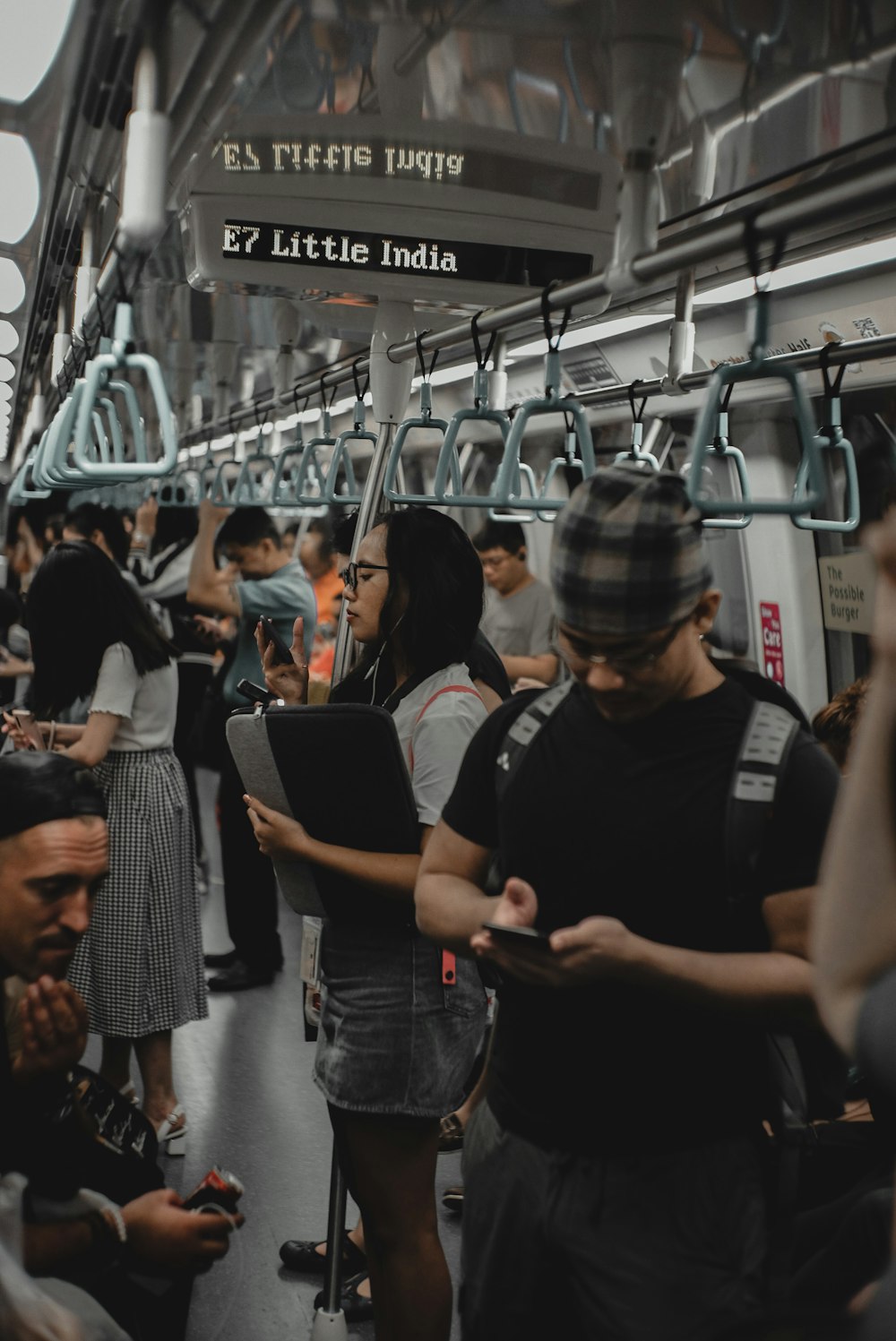 man in black crew neck t-shirt standing in train