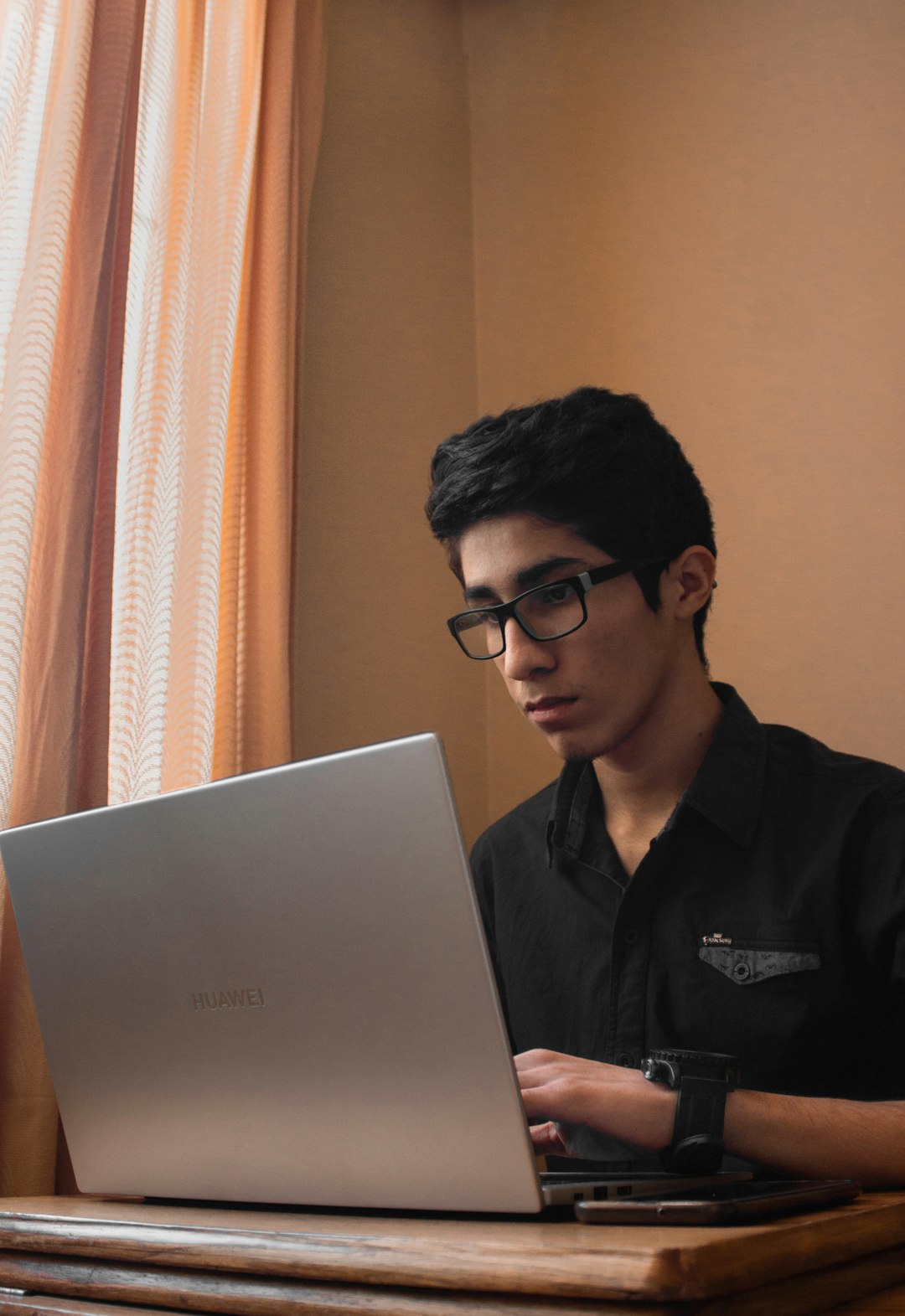 man in black polo shirt using gray asus laptop