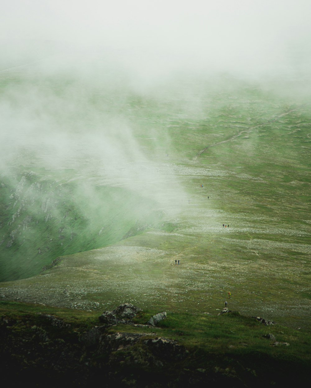 green grass covered mountain with white smoke