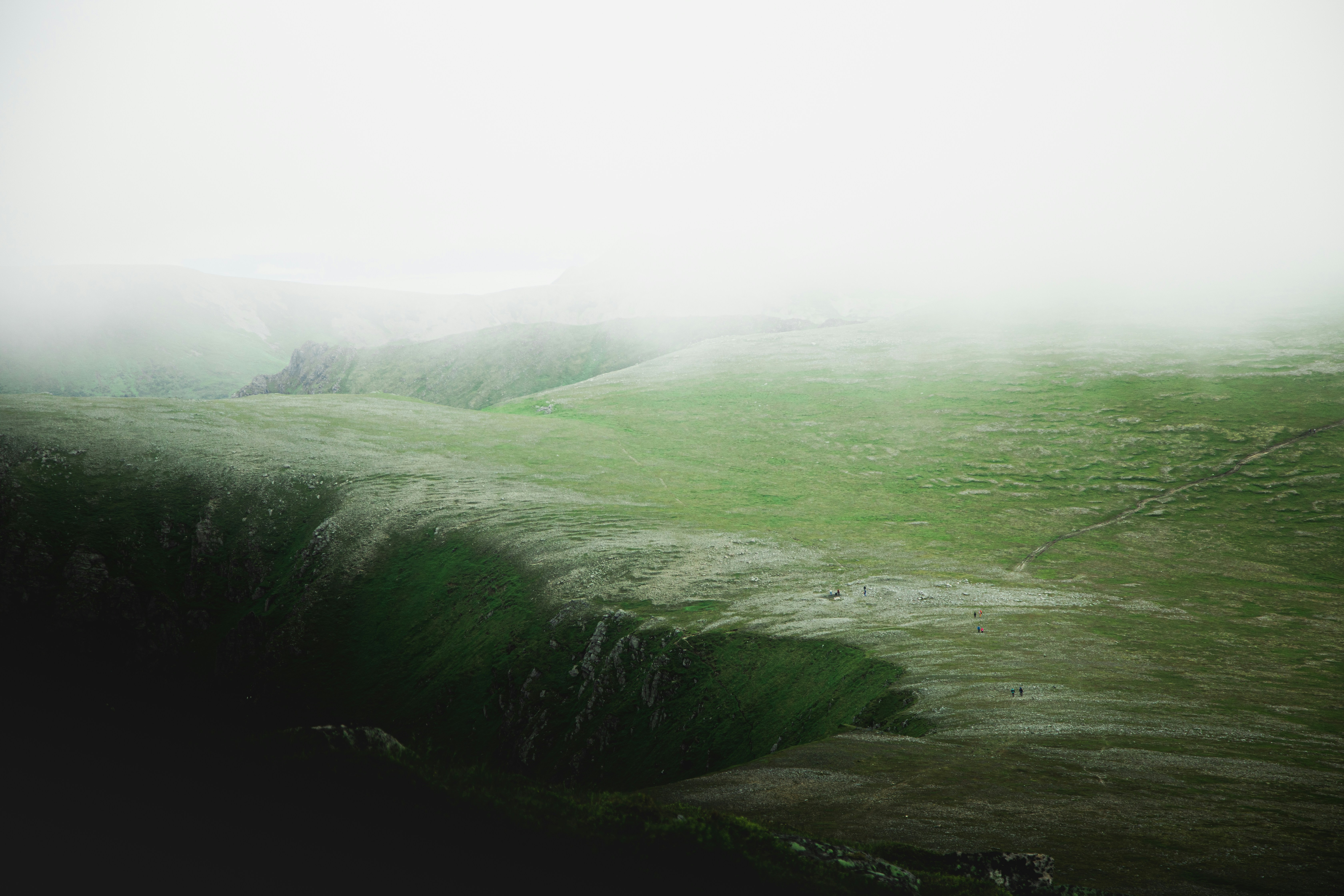green grass covered hill under white sky during daytime