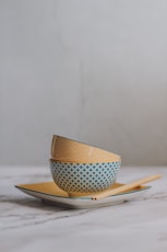 white and blue polka dot ceramic mug on white and blue plate