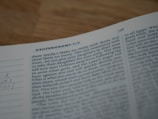 A close-up of an open book focusing on a passage from Deuteronomy 7:3-4. The text appears typed in a standard font and is slightly out of focus.