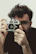 Portrait of Alexandre Calandrini smiling, holding his vintage camera.