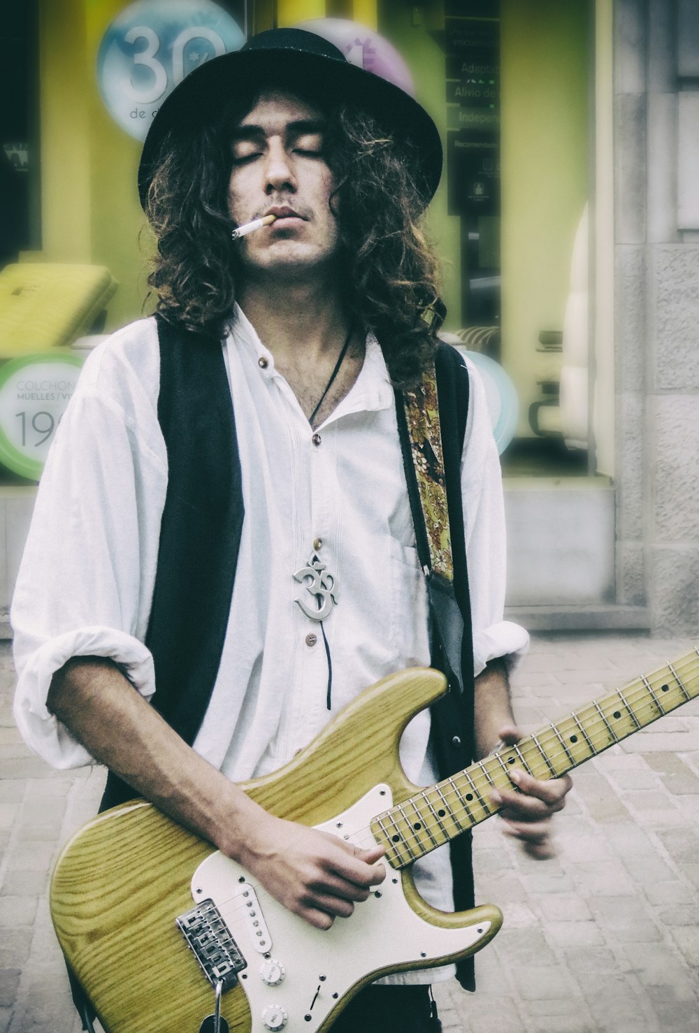 man in white button up shirt playing electric guitar