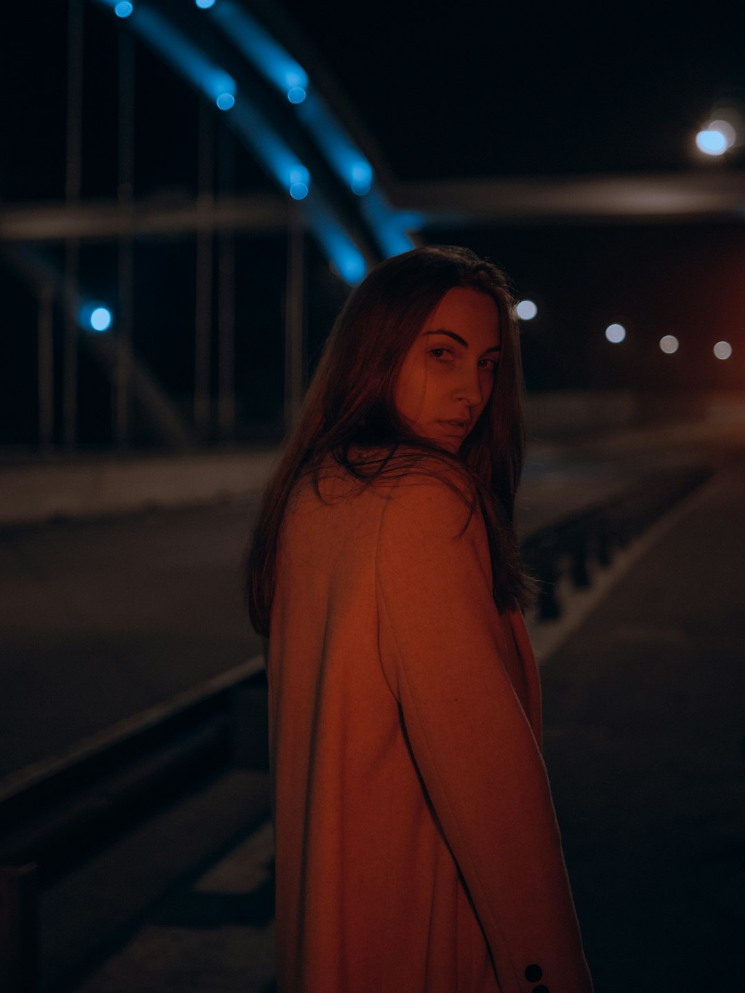 woman in brown long sleeve shirt standing on road during night time