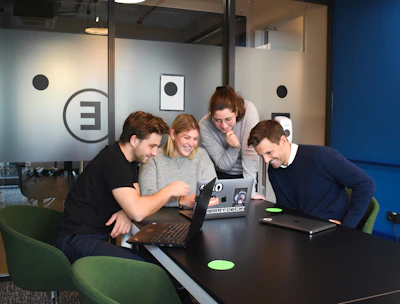 A smiling group of diverse writers chatting during a virtual Zoom meeting.