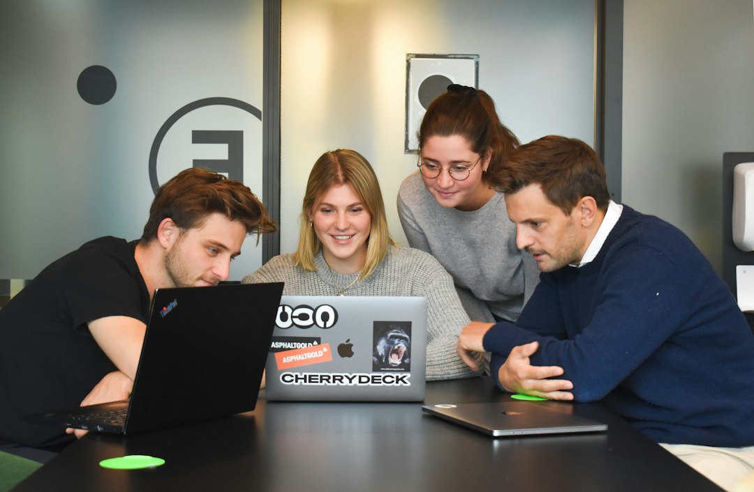 A design agency team works around a laptop in a studio