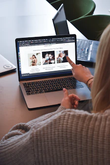 woman in brown sweater using macbook pro