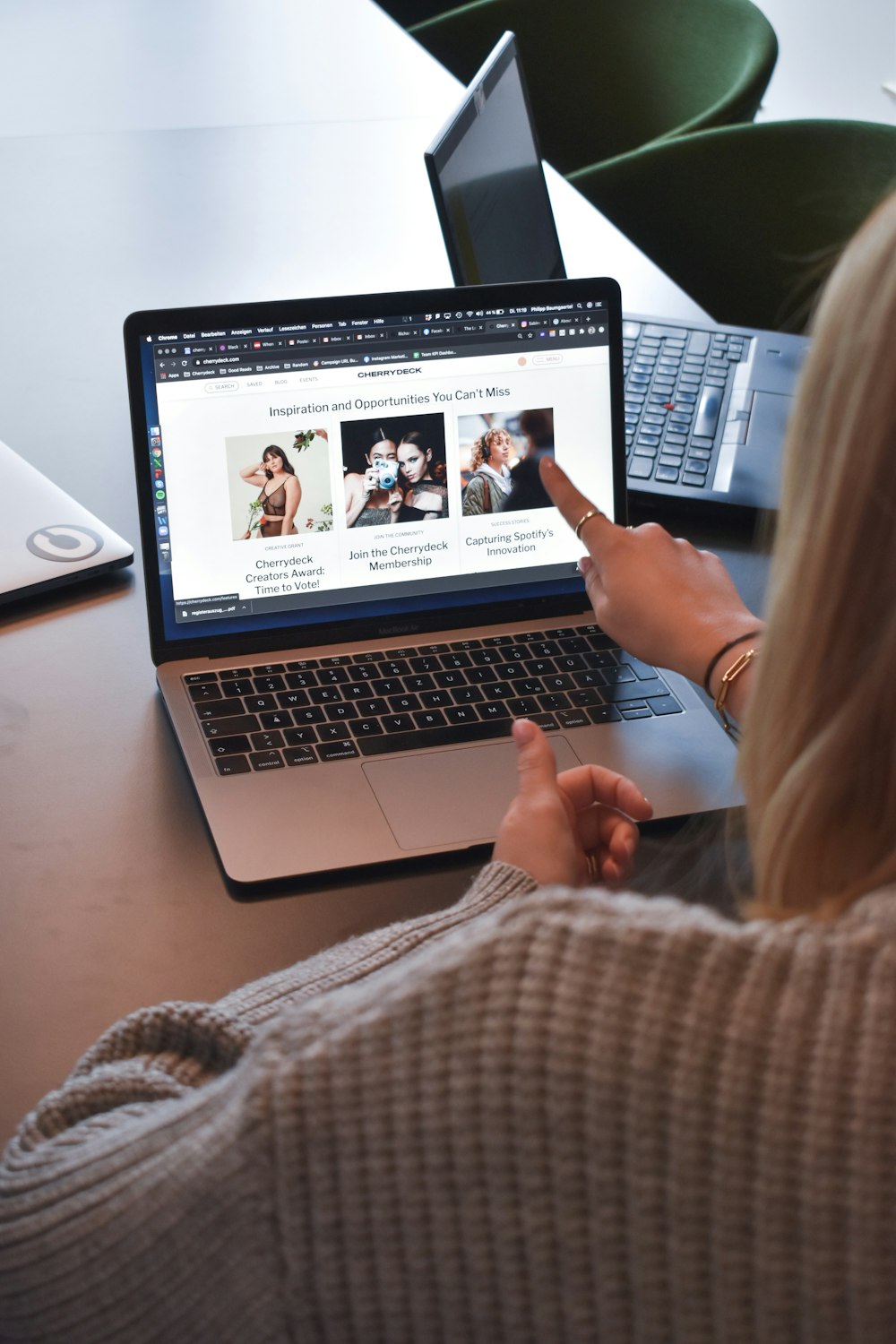 Frau in braunem Pullover mit MacBook Pro