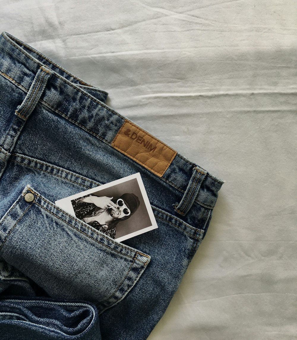 blue denim jeans on white textile