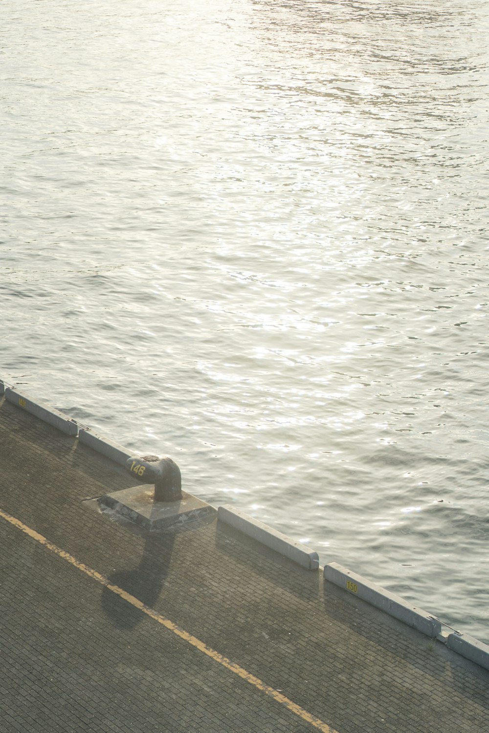 Muelle de hormigón marrón sobre el cuerpo de agua durante el día