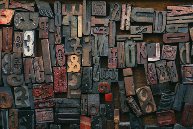 Antique wooden letterforms and printing blocks arranged in a typesetter's case