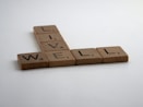 brown wooden letter blocks on white surface