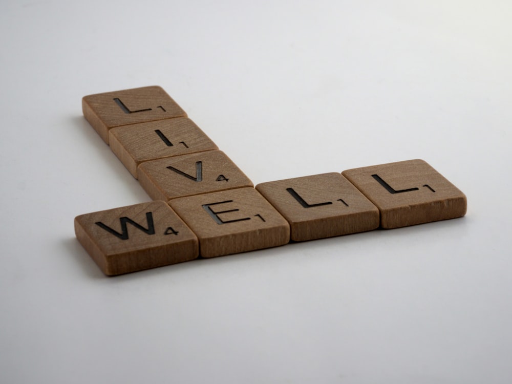 blocs de lettres en bois brun sur surface blanche