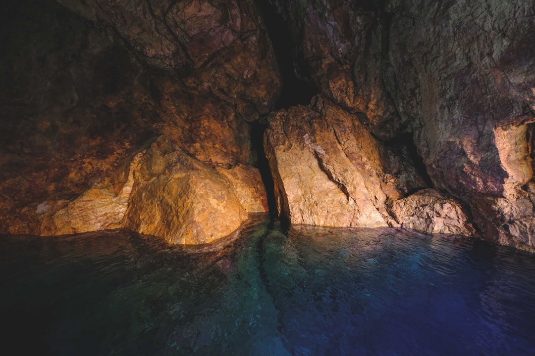 brown rock formation on body of water during daytime