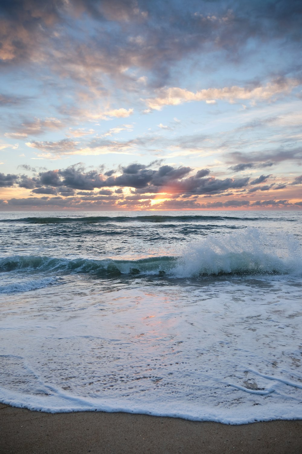 ondas do oceano sob o céu nublado durante o dia