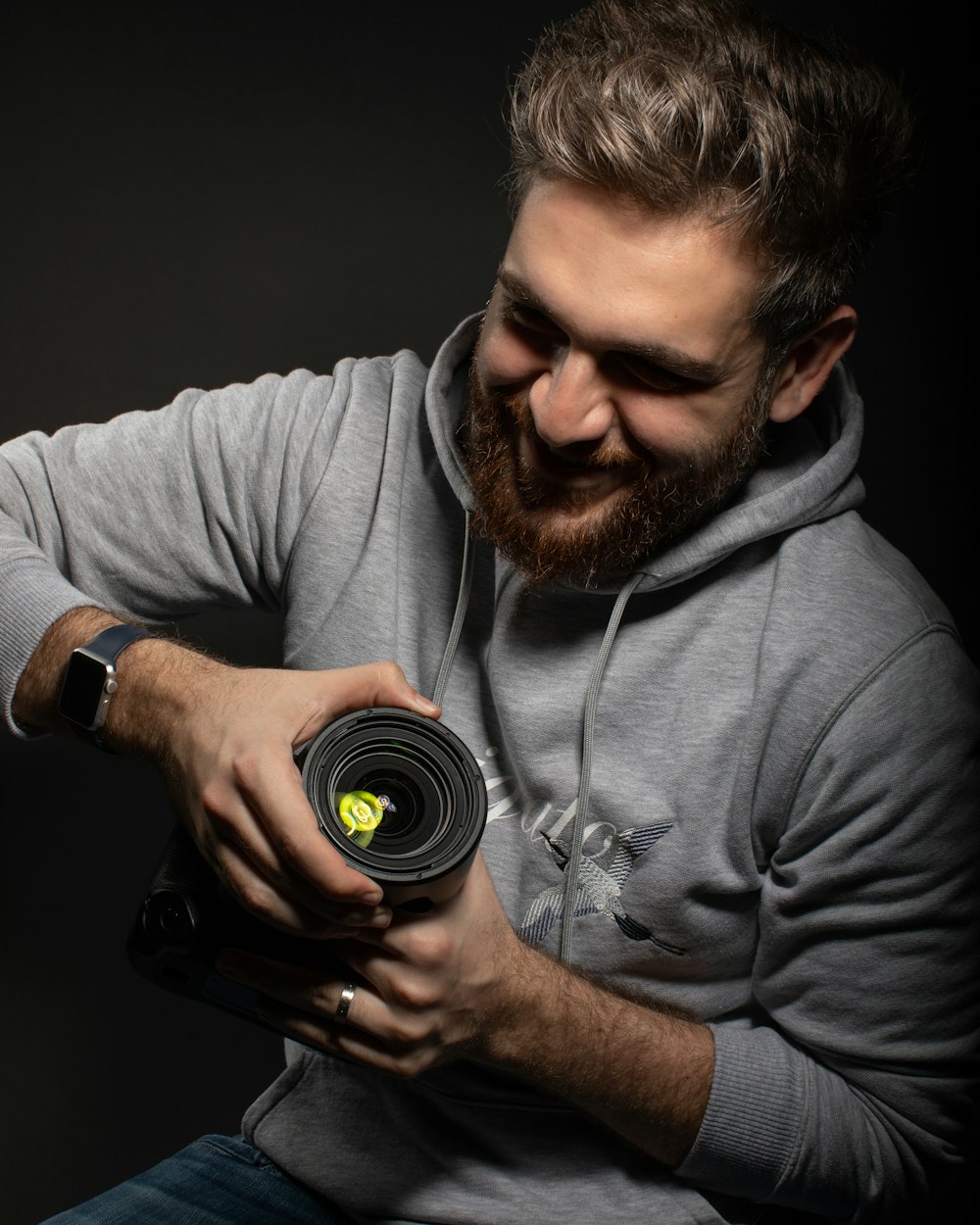 man in gray long sleeve shirt holding black dslr camera