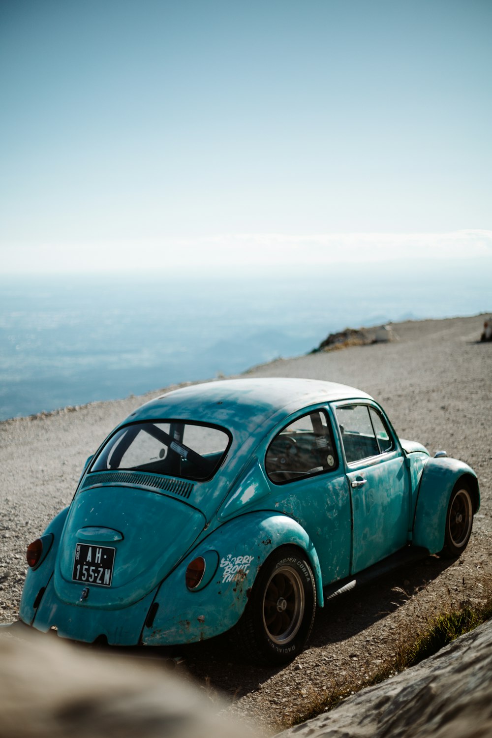 Escarabajo Volkswagen verde sobre arena marrón durante el día