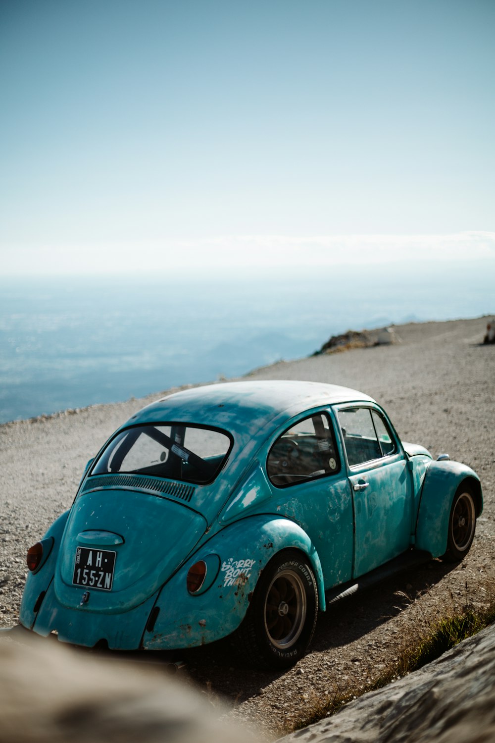 green volkswagen beetle on brown sand during daytime