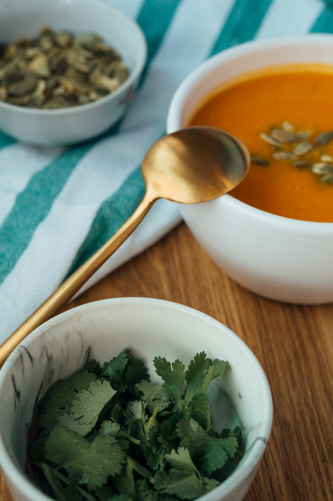 soup in white ceramic bowl beside stainless steel spoon