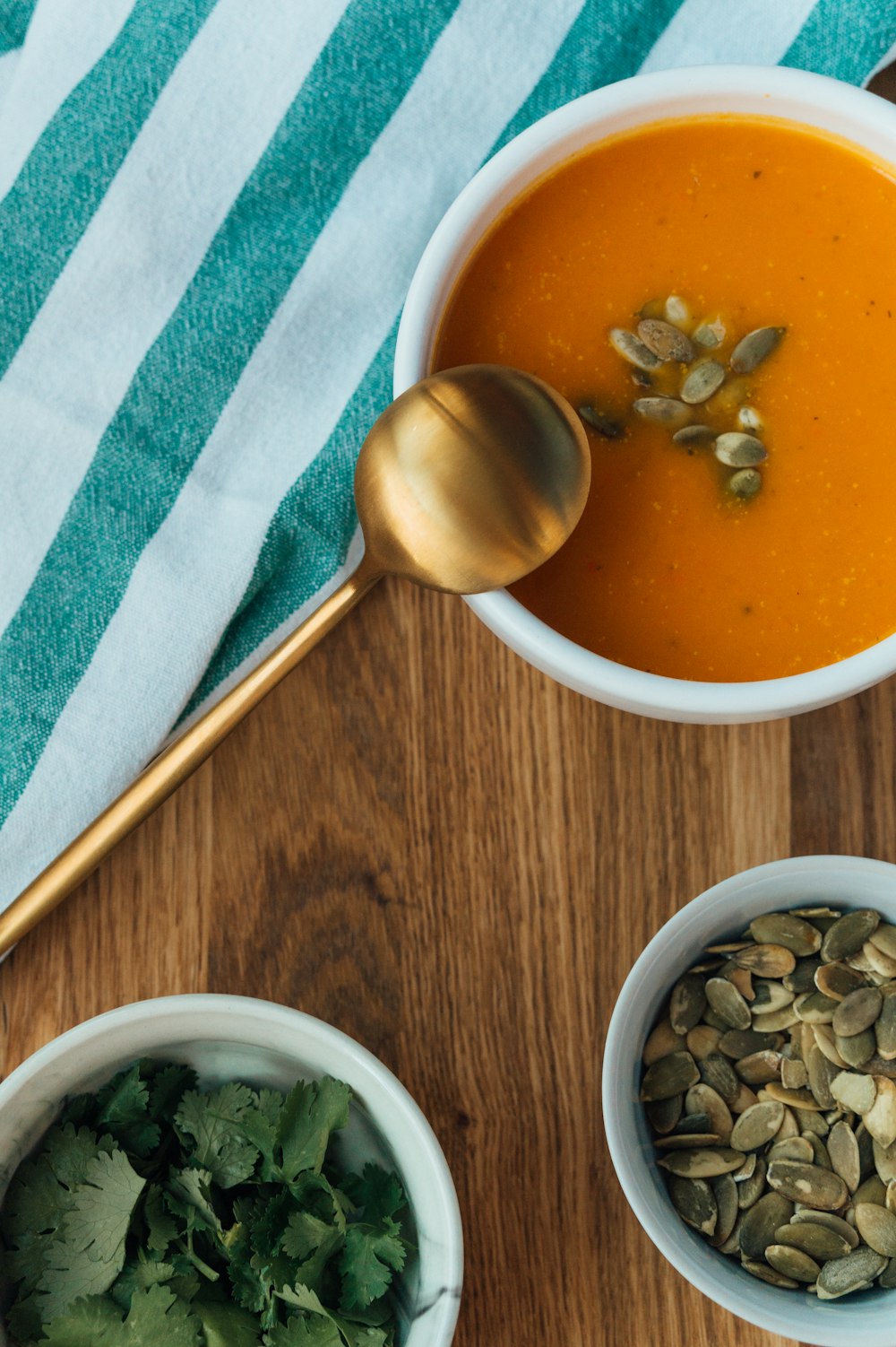 white ceramic bowl with soup and stainless steel spoon