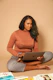 woman in brown long sleeve shirt and gray pants sitting on gray couch