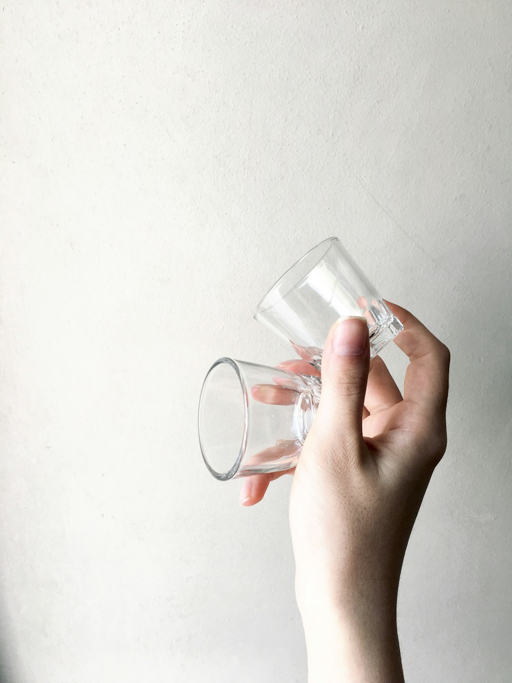 persona sosteniendo un vaso transparente