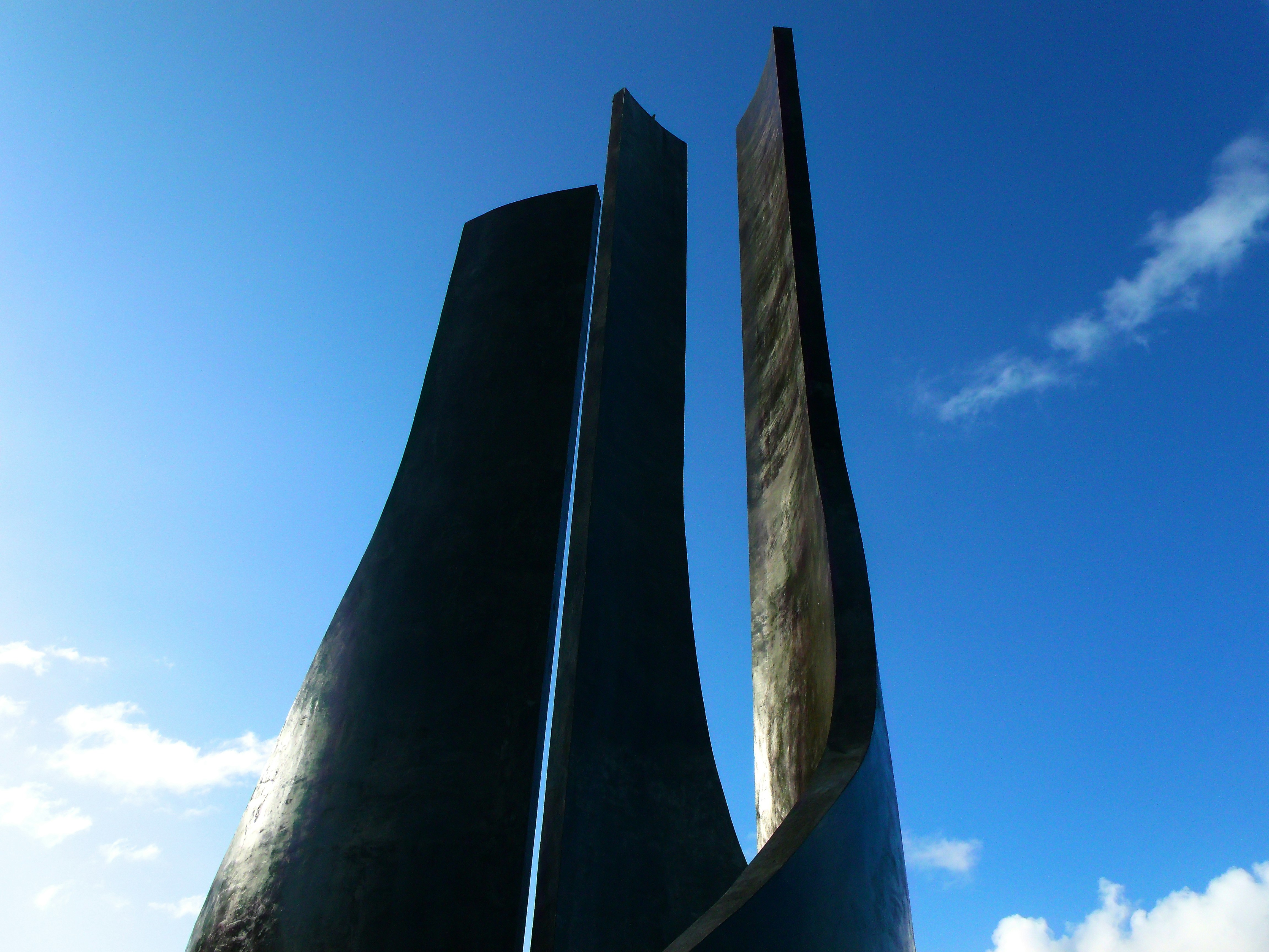 a couple of tall metal sculptures sitting next to each other
