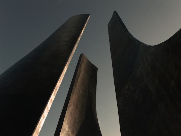 a couple of tall black sculptures sitting next to each other