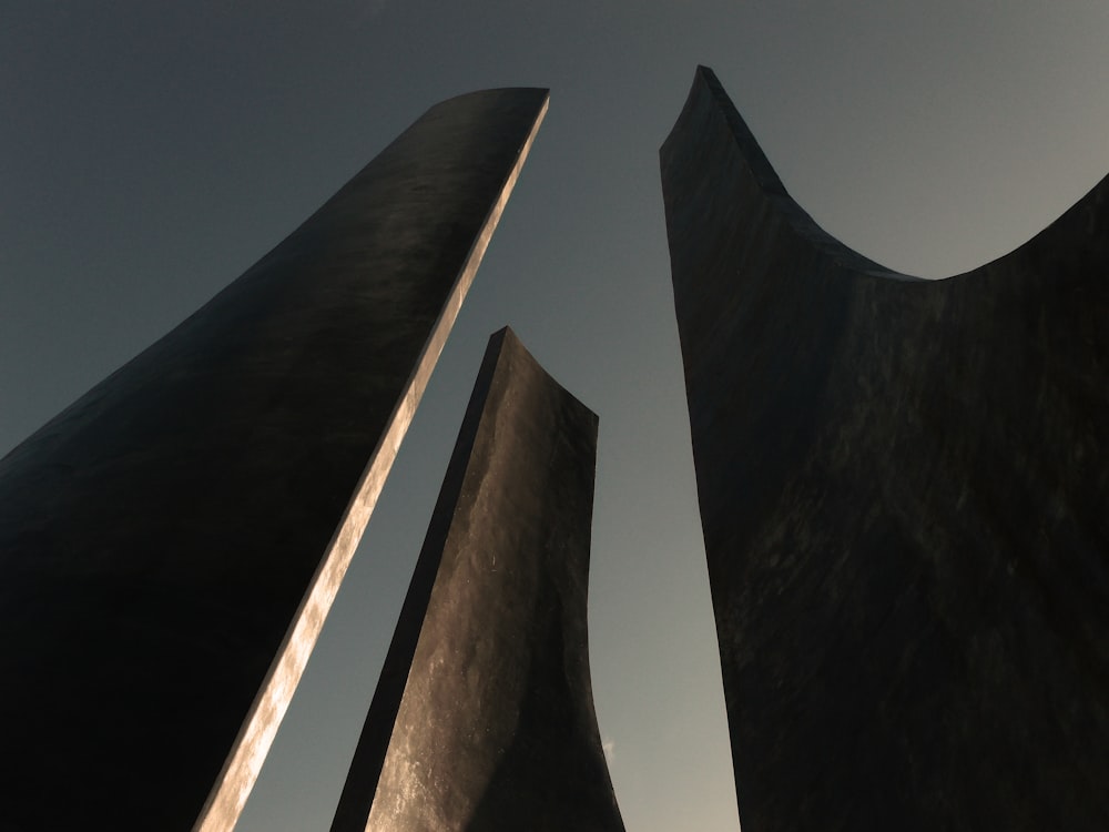 a couple of tall black sculptures sitting next to each other