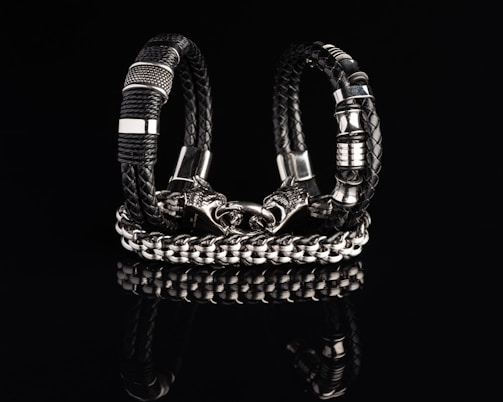 A leather bracelet adorned with a dragon-shaped metal clasp, worn on a strong wrist.